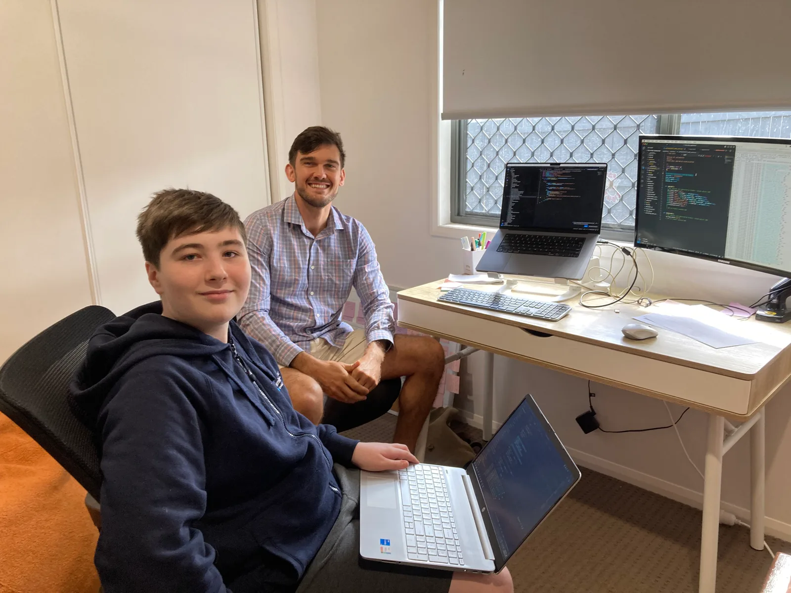 Billy and Eru at the desk during the work experience week, laptops open